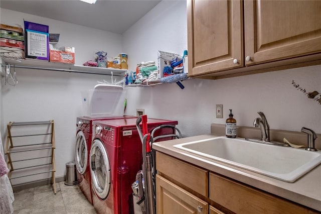 laundry room with sink, washing machine and clothes dryer, and cabinets