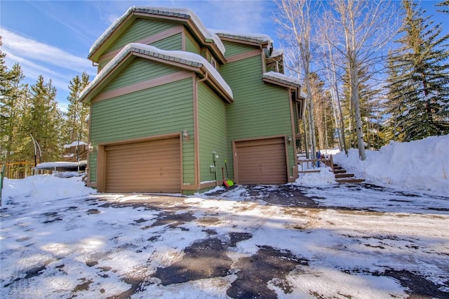 view of snowy exterior with a garage