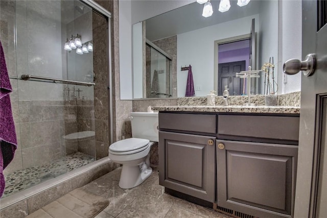 bathroom featuring a shower with door, tile patterned flooring, vanity, and toilet