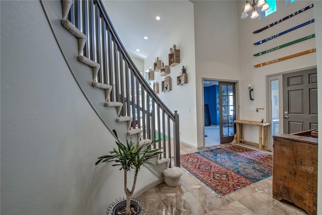 foyer entrance featuring a towering ceiling and an inviting chandelier