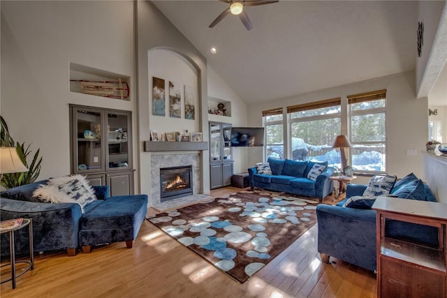 living room with hardwood / wood-style flooring, high vaulted ceiling, and ceiling fan