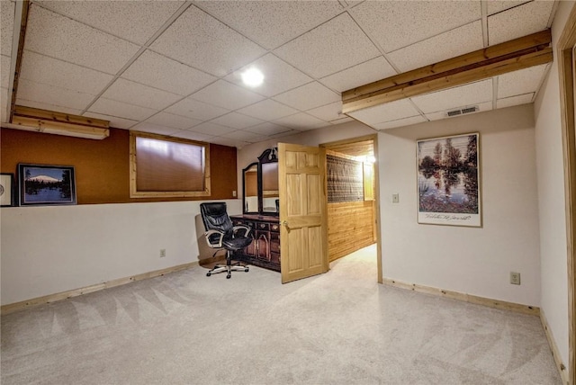 unfurnished office with a paneled ceiling and carpet