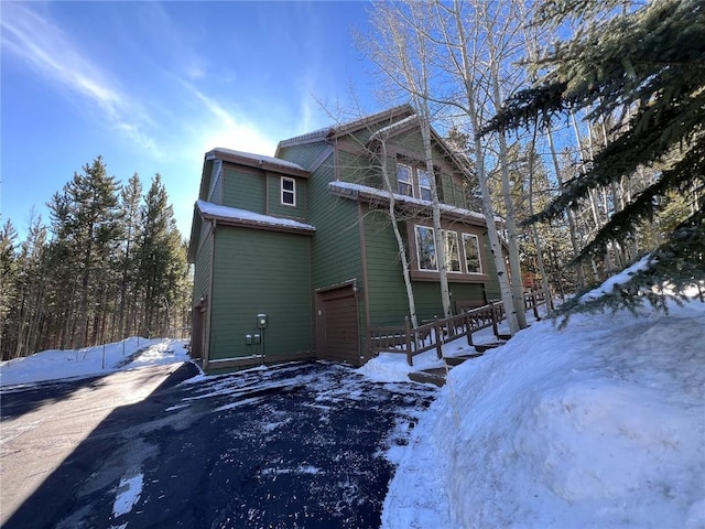 view of snowy exterior with a garage