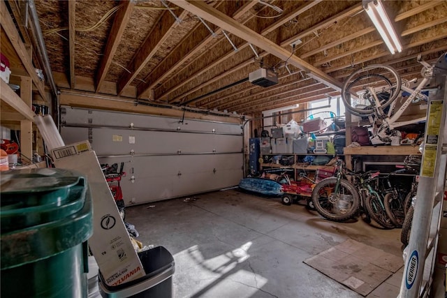 garage with a garage door opener and a workshop area