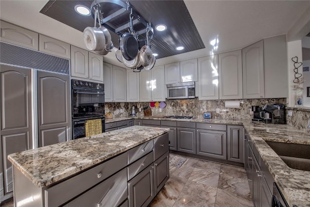 kitchen with black appliances, gray cabinets, and light stone countertops