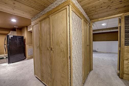 hall featuring light carpet and wood ceiling