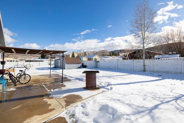 yard layered in snow featuring a storage shed