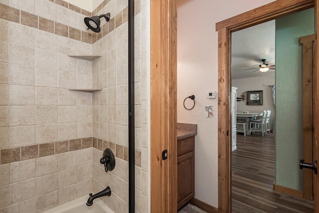 bathroom featuring ceiling fan, wood-type flooring, tiled shower / bath, and vanity