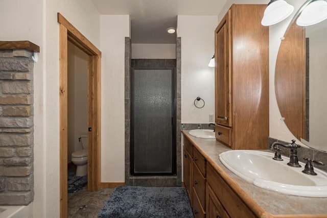 bathroom with vanity, a shower with shower door, and toilet