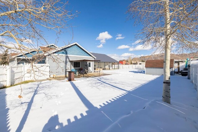 snow covered back of property with a storage shed