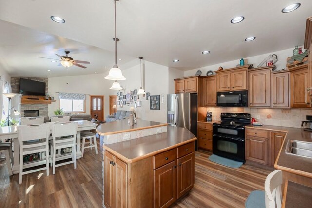 kitchen with decorative backsplash, vaulted ceiling, ceiling fan, black appliances, and pendant lighting