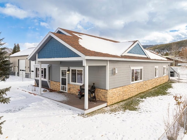 snow covered house with a wooden deck