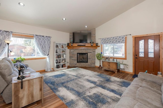 living room featuring a stone fireplace, lofted ceiling, and wood-type flooring