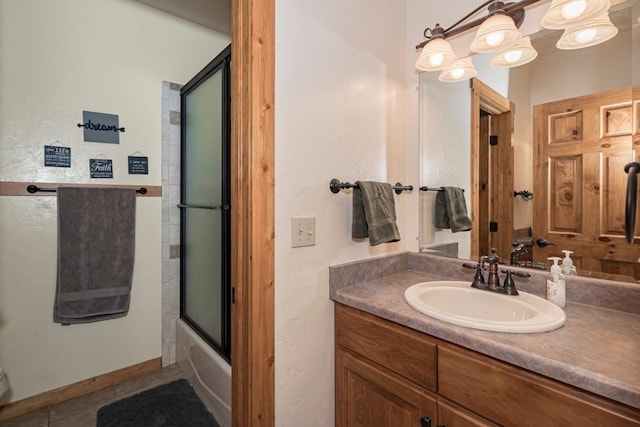 bathroom with shower / bath combination with glass door, vanity, and tile patterned flooring