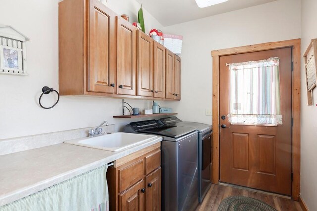 washroom with light hardwood / wood-style floors, cabinets, independent washer and dryer, and sink