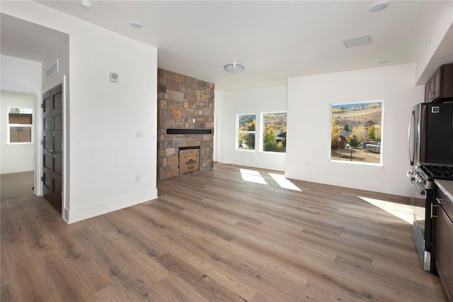 unfurnished living room featuring light wood-type flooring and a fireplace