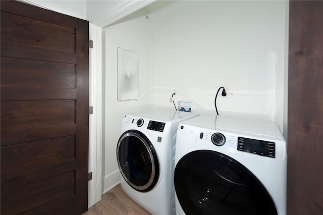 washroom with washer and dryer and light wood-type flooring