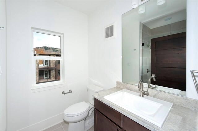 bathroom with tile patterned flooring, vanity, toilet, and a shower with door