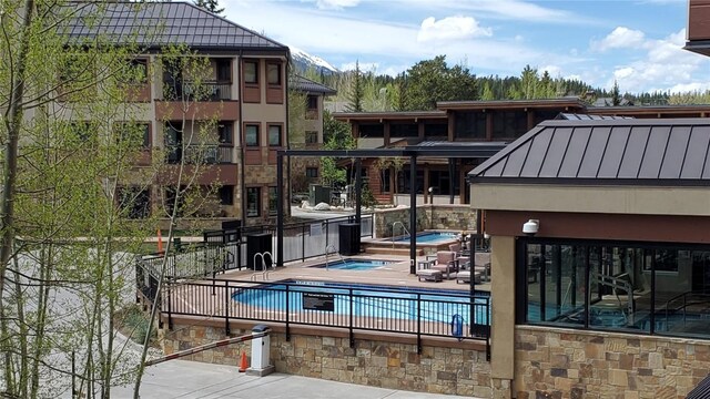 view of pool featuring a community hot tub and a patio