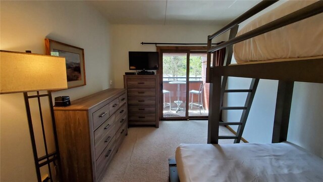 bedroom with access to outside and light colored carpet