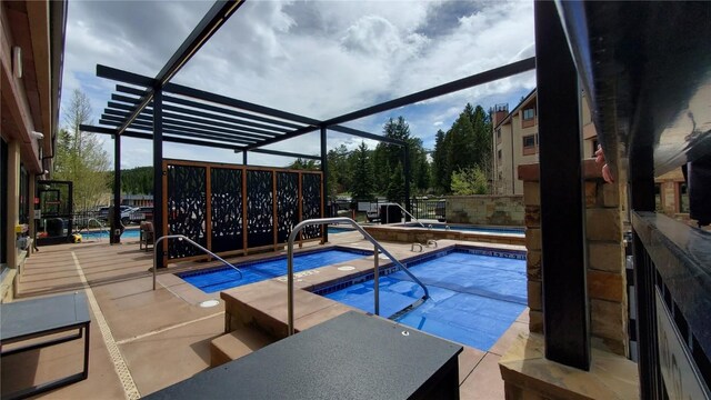 view of pool featuring a lanai, a hot tub, and a patio