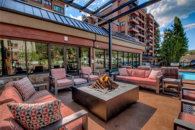 view of patio / terrace with an outdoor living space with a fire pit