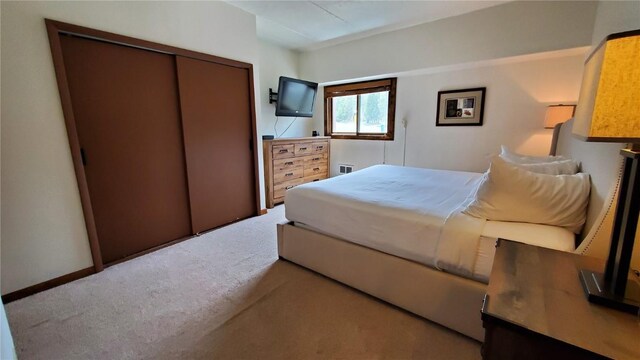 bedroom with light colored carpet and a closet