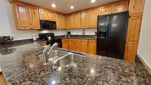 kitchen with sink, black appliances, kitchen peninsula, and dark stone counters