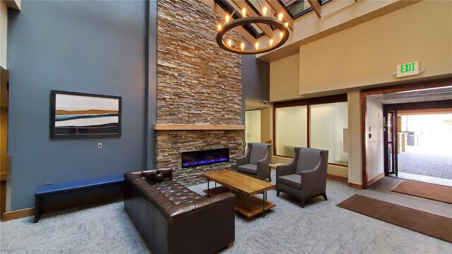 carpeted living room with an inviting chandelier, a fireplace, and a high ceiling