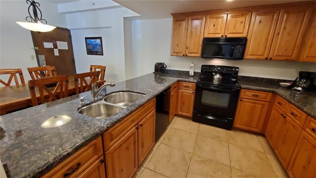 kitchen with dark stone countertops, sink, pendant lighting, and black appliances