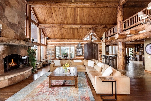 living area with high vaulted ceiling, a fireplace, beamed ceiling, and hardwood / wood-style floors