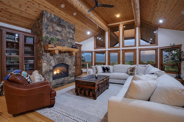 living room featuring wooden ceiling, beamed ceiling, high vaulted ceiling, light hardwood / wood-style floors, and a fireplace