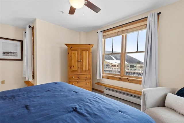 bedroom with ceiling fan, a mountain view, and baseboard heating