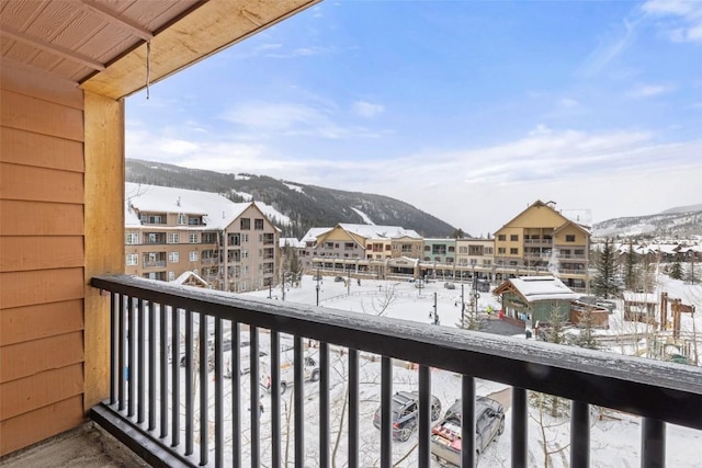 snow covered back of property featuring a mountain view