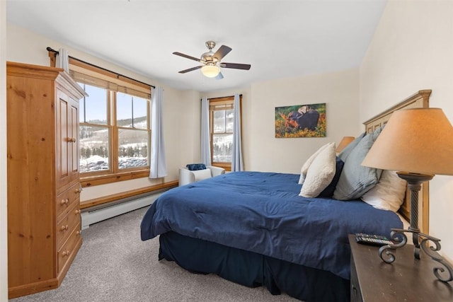 carpeted bedroom with ceiling fan and a baseboard heating unit