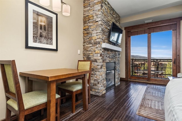 dining area featuring dark wood-type flooring and a fireplace