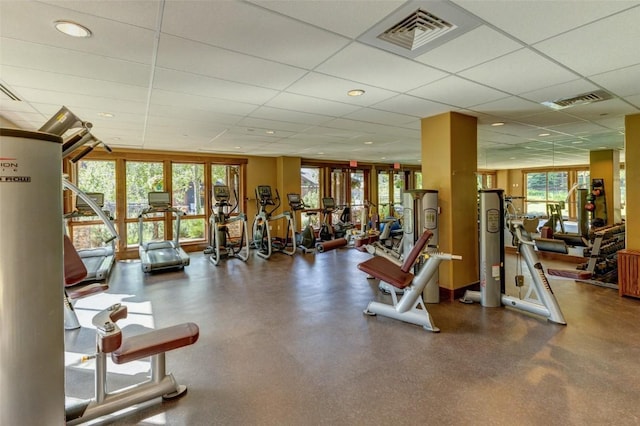 workout area with a paneled ceiling and a healthy amount of sunlight