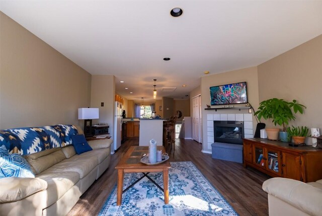 living room with dark hardwood / wood-style flooring and a fireplace