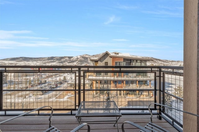 snow covered back of property featuring a mountain view