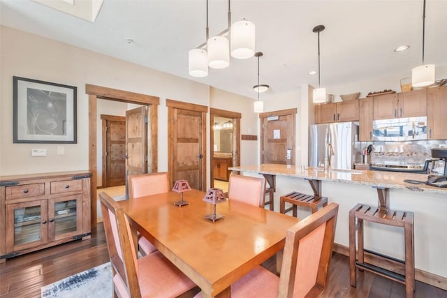 dining space with dark hardwood / wood-style floors and sink