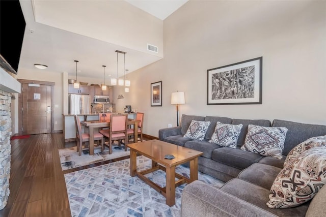 living room featuring a towering ceiling and wood-type flooring