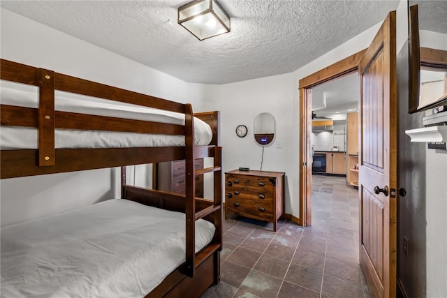 bedroom featuring dark tile patterned floors and a textured ceiling