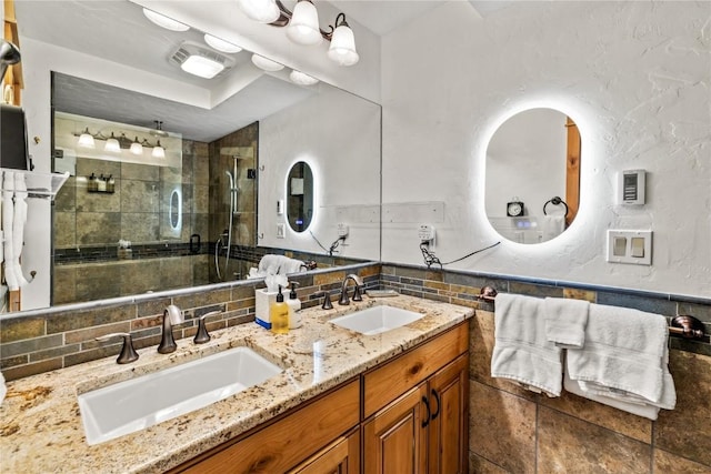 bathroom with walk in shower, vanity, and tile walls