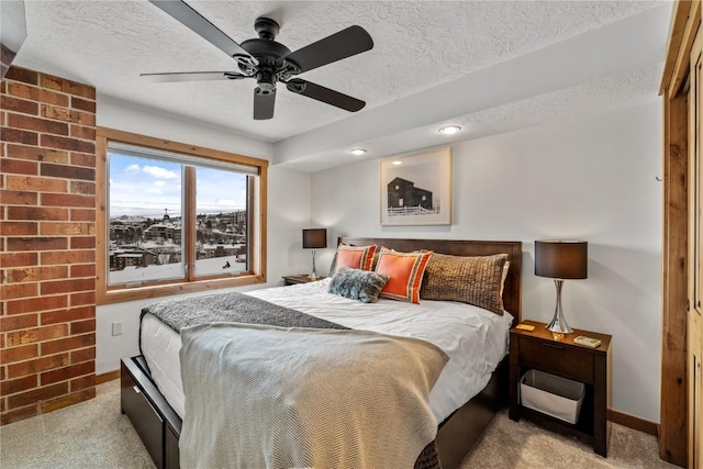 carpeted bedroom with ceiling fan and a textured ceiling