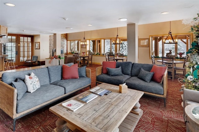 living room featuring a notable chandelier and french doors