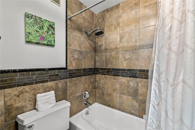 bathroom with tile walls, toilet, and shower / bath combo with shower curtain