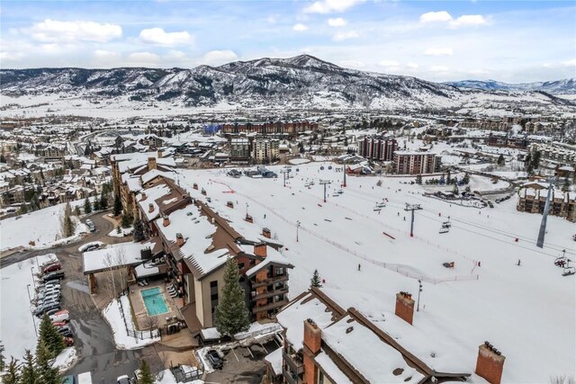 snowy aerial view featuring a mountain view