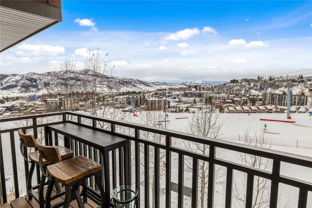 snow covered back of property with a mountain view