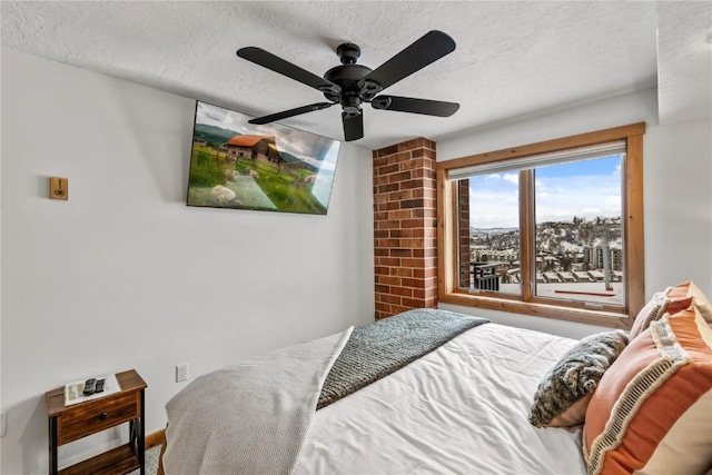 bedroom with ceiling fan and a textured ceiling