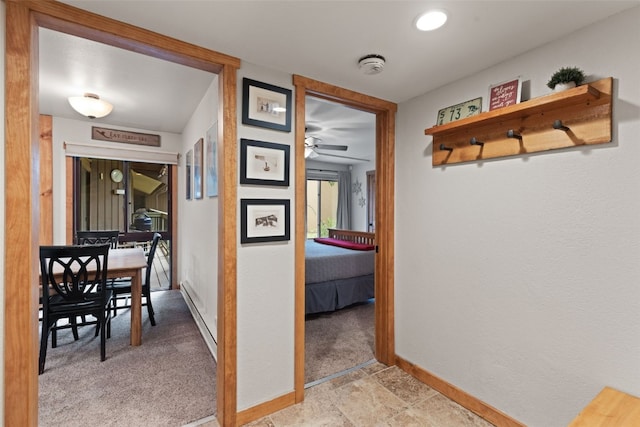 hall with light colored carpet and a baseboard radiator